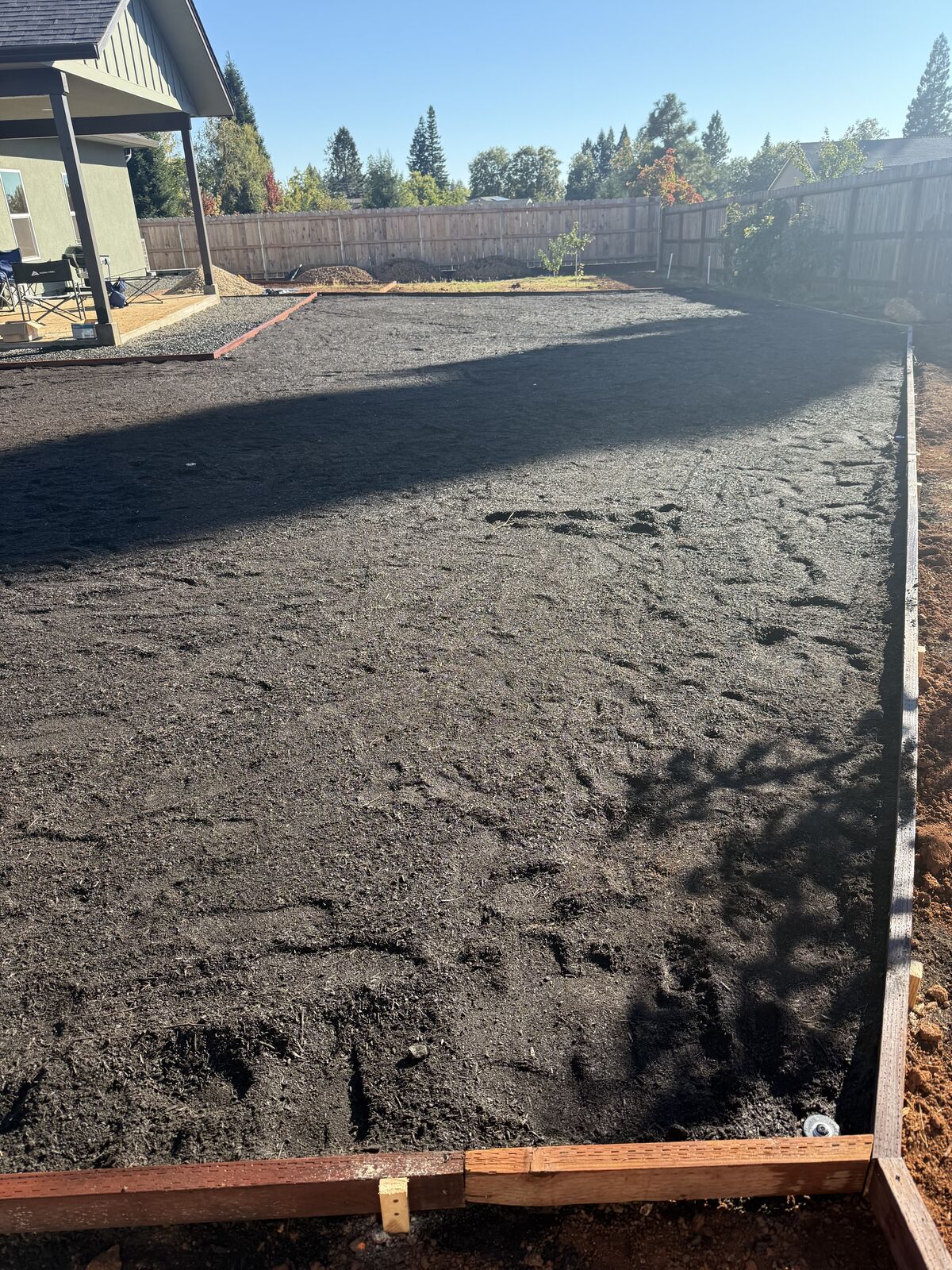 Bare, rough backyard before mowing and lawn care service